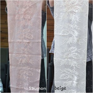 May include: Two crocheted table runners, one in salmon pink and one in beige. Both runners feature a delicate floral pattern.