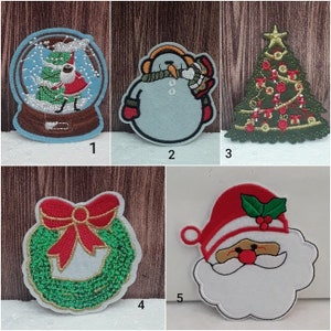 Peut inclure: Cinq patchs brodés sur le thème de Noël à repasser. Les patchs comprennent un globe à neige avec un sapin de Noël et le Père Noël à l'intérieur, un bonhomme de neige avec une écharpe et un chapeau, un sapin de Noël avec des décorations, une couronne avec un nœud rouge et un Père Noël avec une barbe blanche.