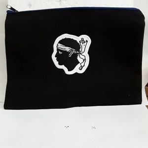 Può includere: Borsa nera con cerniera con una toppa ricamata bianca di una testa con una fascia e un nastro. La borsa ha una cerniera blu.