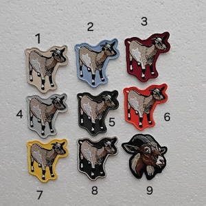 Könnte beinhalten: Neun gestickte Bügelbilder mit verschiedenen farbigen Ziegen. Die Patches sind von 1 bis 9 nummeriert.