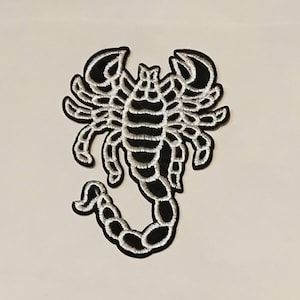 Op de afbeelding: Zwarte en witte geborduurde schorpioen patch. De schorpioen is naar rechts gericht met zijn staart omhoog gekruld. De patch heeft een witte omtrek en een zwarte vulling.