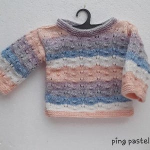 Peut inclure: Un pull en tricot pour bébé de couleur pastel avec un motif rayé dans les tons de rose, bleu et blanc. Le pull a un col rond et des manches longues.