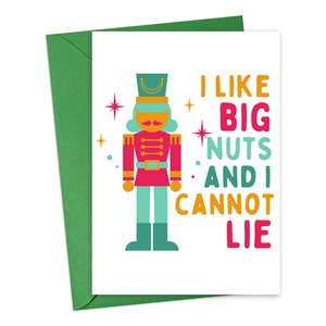 May include: A white greeting card with a green envelope featuring a colorful nutcracker illustration and the text I LIKE BIG NUTS AND I CANNOT LIE in yellow, pink, and teal. The design includes small star accents in pink and yellow.