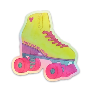 May include: A yellow roller skate with pink wheels and a pink heart on the side. The skate has the text "They See Me Rollin'" written on the side.