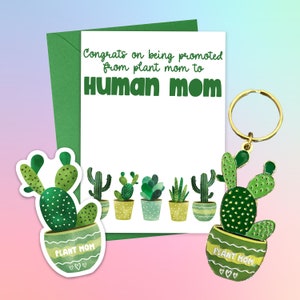 May include: A green card with the text "Congrats on being promoted from plant mom to Human mom".  The card is decorated with a row of potted cacti and succulents.  A green cactus keychain with the text "Plant Mom" is attached to a gold key ring.