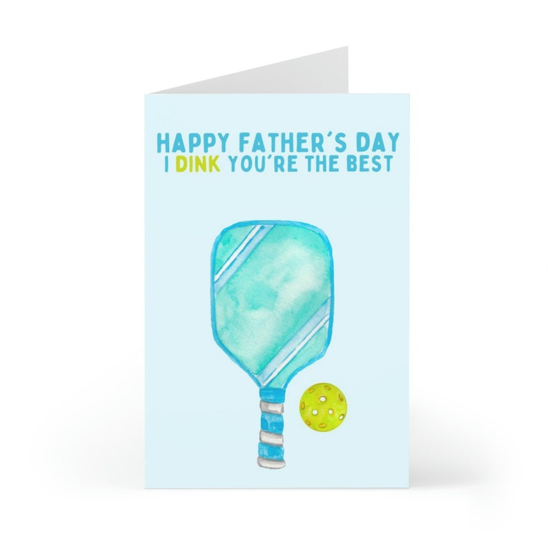 May include: A blue and white paddleball paddle with a yellow ball. The card reads "Happy Father's Day I DINK you're the best".