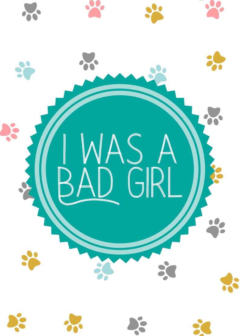 May include: A teal blue circle with a white border and a white starburst design around the edge. The circle has the text "I WAS A BAD GIRL" in white. The background is white with a pattern of grey, pink, and gold paw prints.