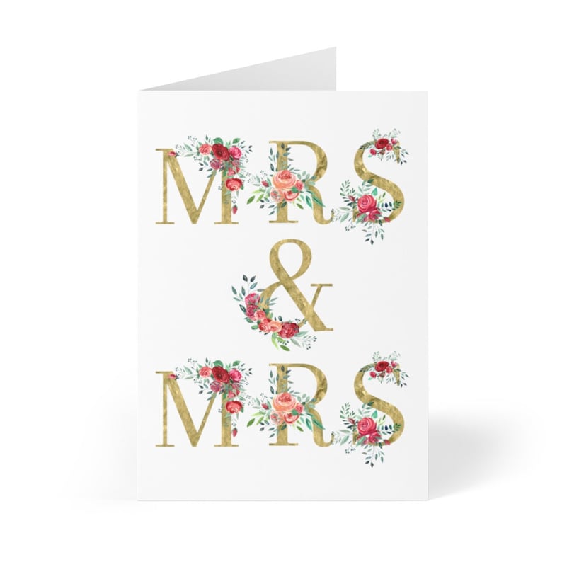 May include: Gold "Mrs. & Mrs." wedding card with floral accents in shades of pink, red, and green.