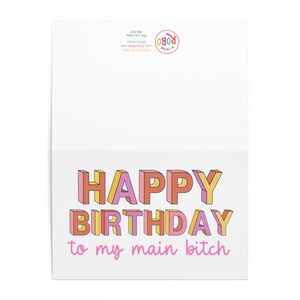 May include: A white card with the text "Happy Birthday to my main bitch" in colorful, 3D-style letters.