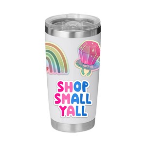 May include: A white insulated tumbler with a silver lid, featuring colorful stickers. Stickers include a rainbow, a pink and purple ring pop with "90's Kid" text, and the text "SHOP SMALL YALL" in pink and blue.