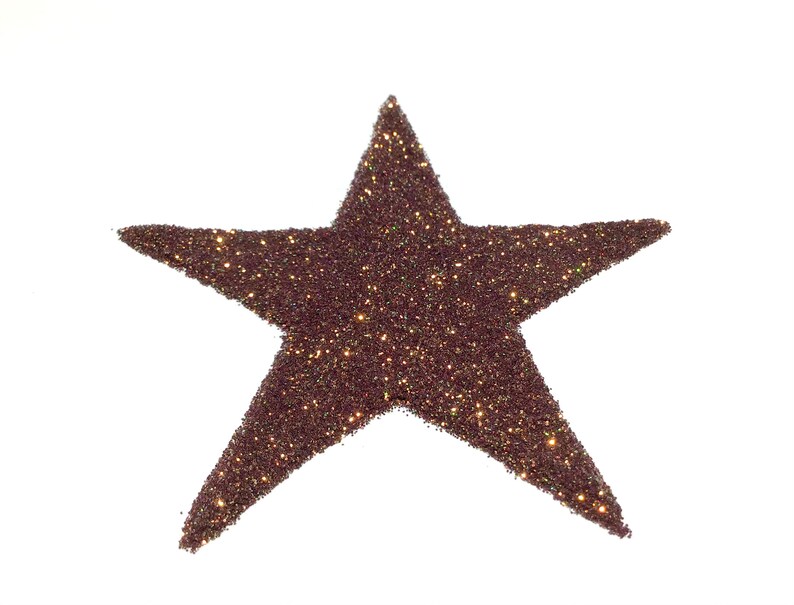 K&ouml;nnte beinhalten: Eine braune Glitzersternform auf wei&szlig;em Hintergrund.