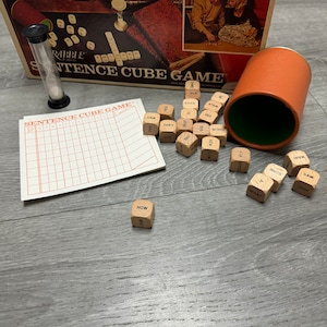 May include: A vintage board game called "Sentence Cube Game" with wooden dice featuring words like "can", "how", "they", "walk", "new", "slow", "what", "some", "saw", "took", "she", "their", "foot", "good", "had", "the", "one", "his", "did", "3.2", "2", "0000", "00", and "100".