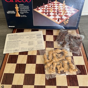 May include: A wooden chess set with a folding board, brown and white chess pieces, and a rule booklet. The box features the text "Family Classics Chess" and "Pressman".