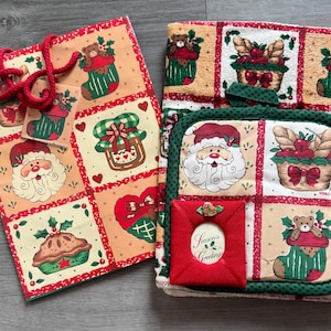 Könnte beinhalten: Eine rechteckige Geschenktüte mit roten Kordelgriffen und passendem Anhänger sowie ein gefaltetes Küchentuch und ein quadratischer Topflappen. Beide Artikel zeigen ein Gittermuster mit Weihnachtsmann, Teddybären in Strümpfen und Gebäck.