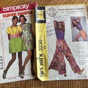 May include: Two vintage sewing patterns for women's clothing. The pattern on the left is Simplicity 8634, a super simple dress or blouse pattern. The pattern on the right is McCall's 3230, a wrap-around pantskirt pattern.