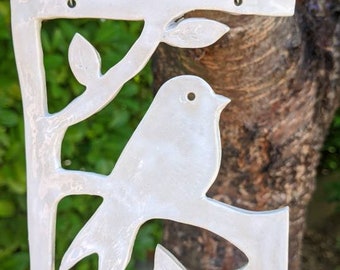 Handmade hanging ceramic bird on a branch