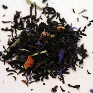 May include: A close-up of a blend of black tea leaves, dried orange peel, and blue cornflower petals.