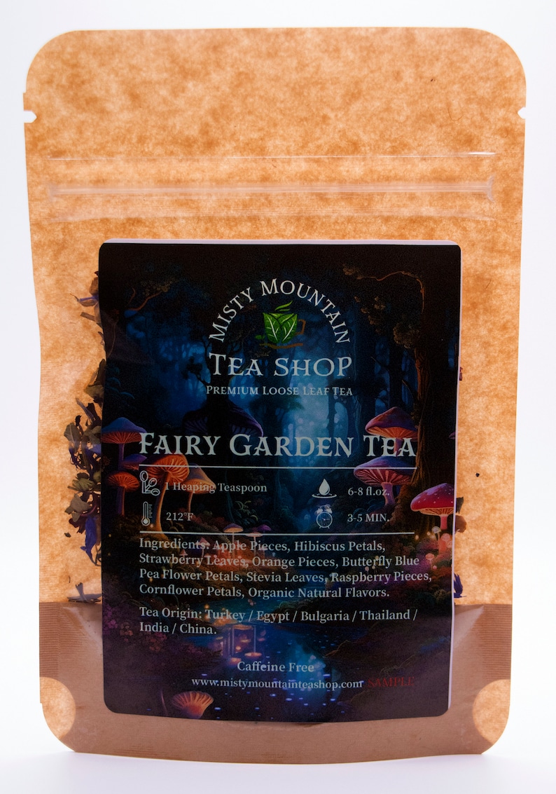 Op de afbeelding: Een bruine papieren zak met een hersluitbare ritssluiting. De voorkant van de zak heeft een kleurrijk etiket met de tekst "Misty Mountain Tea Shop Premium Loose Leaf Tea Fairy Garden Tea". Het etiket bevat ook een lijst met ingredi&euml;nten, instructies voor het zetten en de tekst "Cafe&iuml;nevrij".