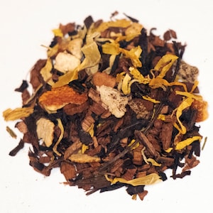 May include: A blend of loose leaf tea with dried orange peel, wood chips, and yellow flower petals.