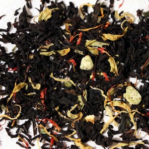 Pu&ograve; includere: Primo piano di un blend di foglie di t&egrave; nero, pezzi di frutta secca e petali di fiori. Il blend di t&egrave; &egrave; un mix di t&egrave; nero, scorza d'arancia secca, pezzi di mela secca e petali di carota selvatica.