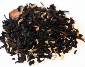 May include: A close-up of a blend of black tea leaves with dried orange peel and other botanicals.