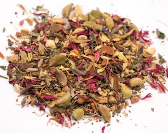 Könnte beinhalten: Nahaufnahme einer Mischung aus getrockneten Kräutern und Gewürzen, darunter grüne Kardamomkapseln, Zimtstangen, getrocknete Blüten und andere Zutaten. Die Mischung ist hellbraun mit rosa und grünen Farbtönen.