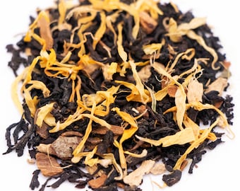May include: A close-up of a blend of black tea leaves, orange peel, and cinnamon sticks. The tea leaves are dark brown and the orange peel is a bright orange. The cinnamon sticks are light brown and have a rough texture.