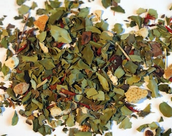 May include: A close-up shot of a pile of dried herbs and spices. The mix includes green leaves, reddish-brown pieces, and small, light-colored fragments. The ingredients are scattered on a white surface, creating a natural, earthy aesthetic.