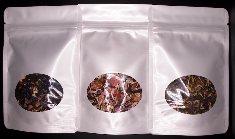 May include: Three white resealable pouches with clear circular windows showing different types of loose leaf tea blends.