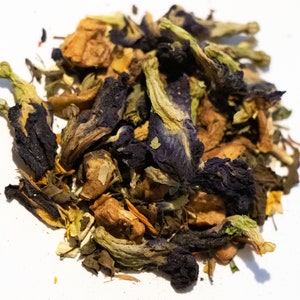 May include: A mix of dried herbs and flowers, including blue butterfly pea flowers, orange and yellow pieces of fruit, and green leaves.