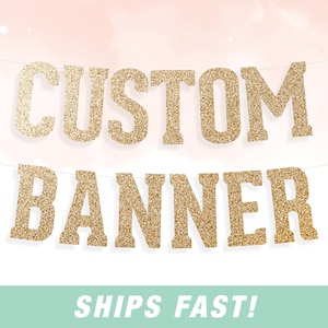 May include: Gold glitter banner with the text "CUSTOM BANNER" in large, bold letters. The banner is hanging from a string and has a light pink background.