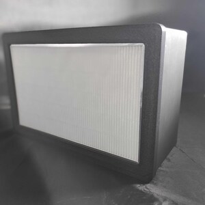 May include: A black rectangular speaker with a white speaker grille.