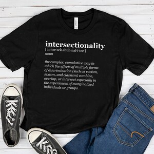 Puede incluir: Camiseta negra con texto blanco que define la palabra "interseccionalidad" en estilo de diccionario. El texto incluye la pronunciación y la definición de la palabra.