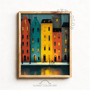 May include: A framed art print showing a row of brightly coloured buildings with lit windows. The buildings are painted in red, teal, yellow, orange, and grey. Bare trees frame the buildings, and two figures walk along a waterfront.