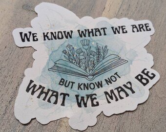 May include: A sticker with a blue watercolor background and an open book with flowers growing from it. The text on the sticker reads "We know what we are but know not what we may be."