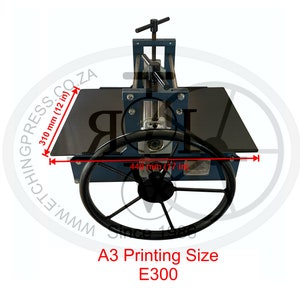 May include: A blue and black etching press with a 17-inch by 12-inch printing surface. The press has a large wheel for turning the press and a handle for adjusting the pressure. The press is labeled "A3 Printing Size E300".