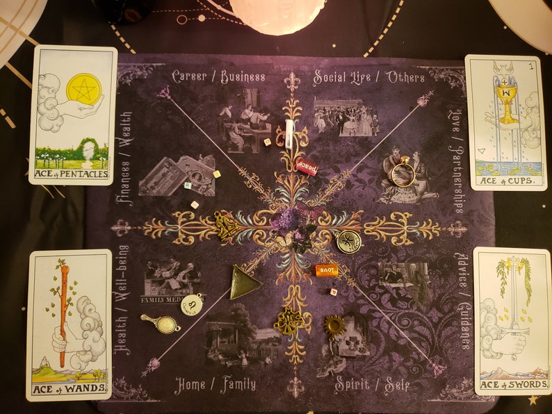 Peut inclure: &Eacute;talement de lecture de cartes de tarot sur un tissu violet avec des accents dor&eacute;s. Les cartes sont dispos&eacute;es en cercle avec l'As de Pentacles, l'As de B&acirc;tons, l'As de Coupes et l'As d'&Eacute;p&eacute;es visibles. Les cartes sont entour&eacute;es de divers charmes et bibelots.