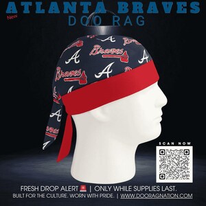 May include: A navy blue Atlanta Braves doo rag with a red band and ties. The doo rag features the team's logo and the word "Braves" in white and red. The text "ATLANTA BRAVES DOO RAG" is at the top.