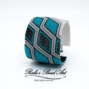 Può includere: Un braccialetto di perline turchese, nero e bianco con un motivo geometrico. Il braccialetto è realizzato da Ralu's Bead Art. ©Tutti i diritti riservati.