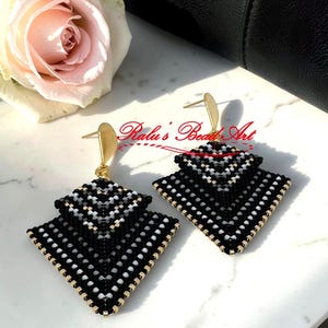 May include: A white ceramic mug with a black handle and the text "But First, Coffee" in a black, bold font. The mug is on a white surface.