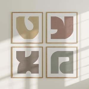 Op de afbeelding: Vier ingelijste abstracte kunstprints met geometrische vormen in gedempte tinten bruin, beige en groen. De prints zijn in een rasterpatroon op een witte muur gerangschikt.