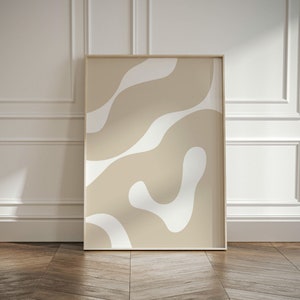 May include: A framed abstract print with a beige background and white abstract shapes. The print is in a simple wooden frame.