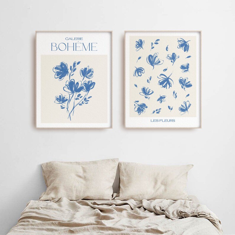 May include: Two framed prints with blue floral illustrations on a cream background. The left print has the text "GALERIE BOHEME" and a single bouquet of flowers. The right print has the text "LES FLEURS" and a pattern of scattered flowers.