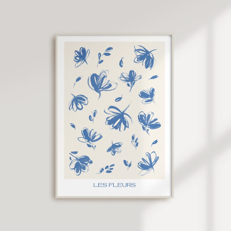 May include: A framed print with a white background and blue abstract floral designs. The text "LES FLEURS" is at the bottom of the print.