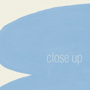 May include: A close-up of a light blue painted surface with the words "close up" written in white.