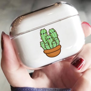 Może przedstawiać: Przezroczyste plastikowe etui na AirPods z uroczym wzorem kaktusa w stylu kreskówkowym. Kaktus jest zielony z brązową doniczką i ma uśmiechniętą buźkę.