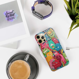 Puede incluir: Una funda transparente para teléfono con un diseño de dibujos animados de colores con varios monstruos y criaturas. La funda está diseñada para un iPhone con una lente de cámara triple.