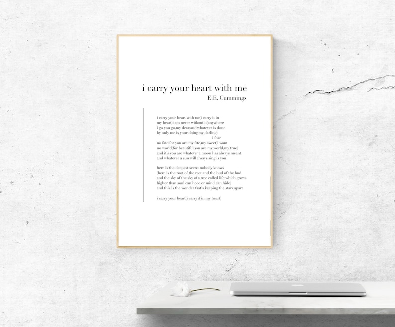 May include: A black and white print of a poem by E.E. Cummings titled "i carry your heart with me". The poem is printed on a white background with a black frame.