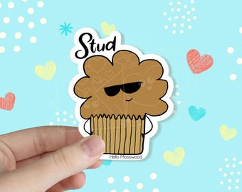 May include: A brown muffin with a white outline and sunglasses, wearing a white shirt and a brown striped skirt. The text "Stud" is written above the muffin. The background is light blue with white polka dots and hearts.