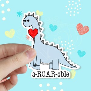 May include: A blue dinosaur holding a red heart balloon with the text "a-ROAR-able".